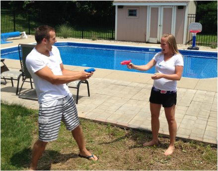 Pool party gender reveal with squirt guns filled with pink or blue paint